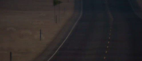 An Empty Highway With A Yellow Flag On The Side GIF