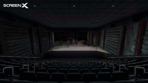 An Empty Movie Theater With The Screen X Logo On The Ceiling GIF