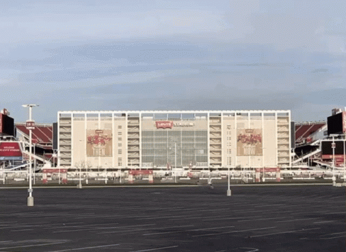 An Empty Parking Lot In Front Of A Large Stadium That Says Levi 'S Stadium GIF