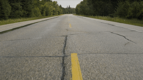 An Empty Road With A Yellow Line On The Side GIF