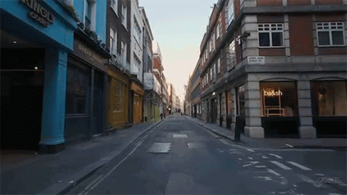 An Empty Street With A Sign That Says Be & Sch GIF