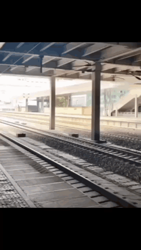 An Empty Train Station With A Few Tracks And A Few Pillars GIF