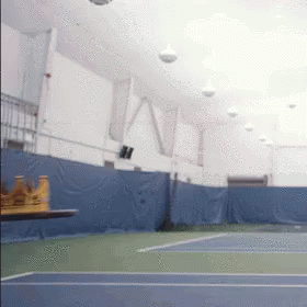 an indoor tennis court with a table in the foreground and the word ny on the wall