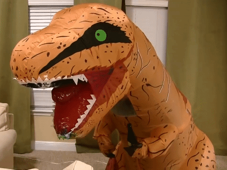 An Inflatable T-Rex With A Green Eye Is Standing In A Living Room GIF