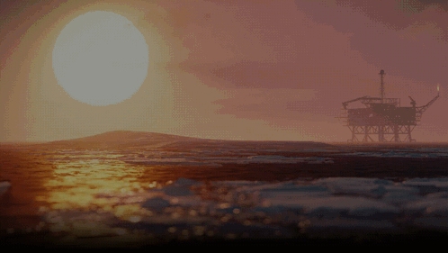 An Oil Rig In The Ocean At Sunset With The Sun Shining Through The Clouds GIF