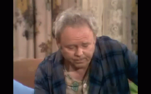 Older Man In Plaid Shirt Sitting On Couch GIF