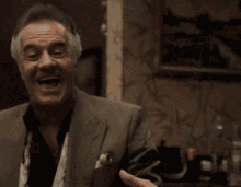 An Older Man In A Suit And Tie Is Laughing GIF