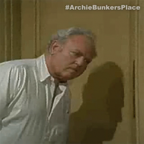 Older Man In White Shirt And Tie Standing By Door GIF