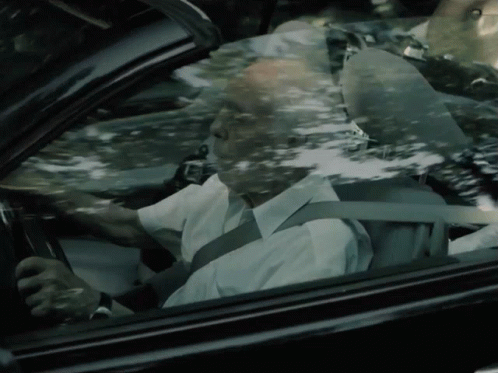 An Older Man Is Driving A Car With A Seat Belt On GIF