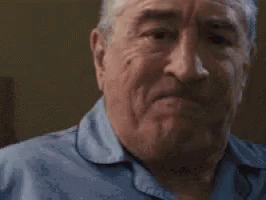 An Older Man Is Making A Funny Face With His Mouth Open And His Eyes Closed . GIF