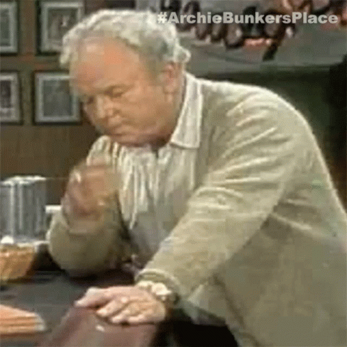 Older Man Looking At Something With Hands On Table GIF