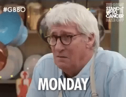 An Older Man Wearing Glasses And A Blue Shirt Is Sitting At A Table . GIF