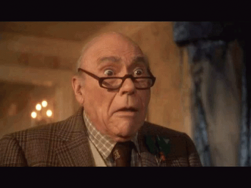 An Older Man Wearing Glasses And A Suit Has A Surprised Look On His Face GIF