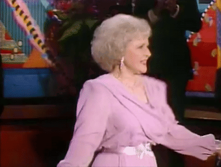 An Older Woman In A Purple Dress Is Dancing On A Stage GIF