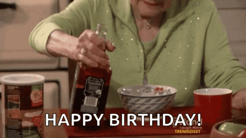 An Older Woman Is Sitting At A Table With A Bowl Of Cereal And A Bottle Of Sauce . GIF