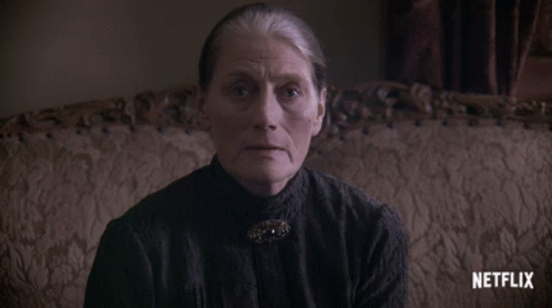 An Older Woman Sitting On A Couch With A Netflix Logo On The Bottom GIF