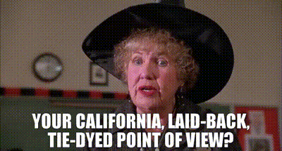 An Older Woman Wearing A Black Hat Says Your California Laid Back Tie-Dyed Point Of View ? GIF