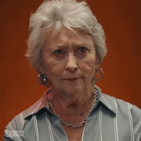 an older woman wearing a striped shirt and a necklace with comedy central on the bottom