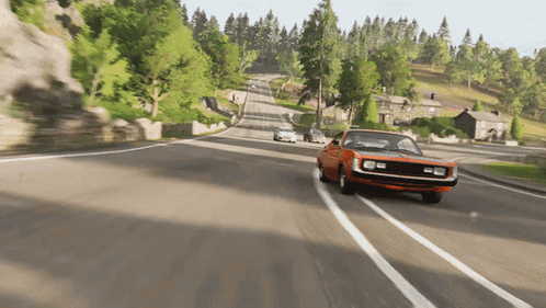 An Orange Car Is Driving Down A Road With Trees On The Side GIF