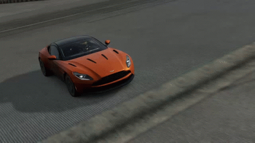 An Orange Car With A Black Roof Is Driving On A Road GIF