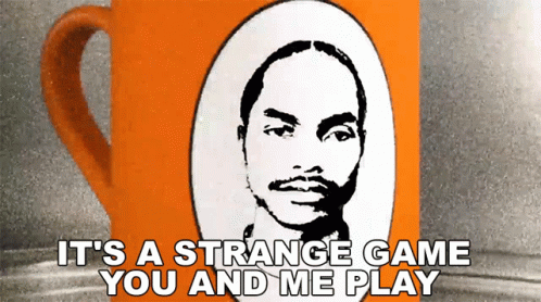 An Orange Coffee Mug With A Picture Of A Man And The Words It 'S A Strange Game You And Me Play GIF