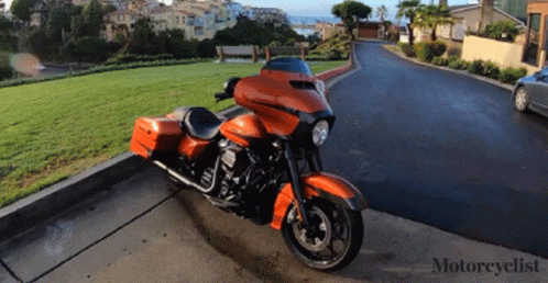 An Orange Harley Davidson Motorcycle Is Parked On The Curb GIF