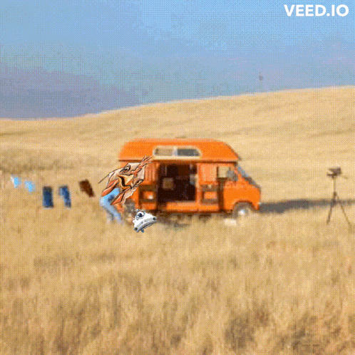An Orange Van Is Parked In The Middle Of A Field With The Words Veed.io Above It GIF