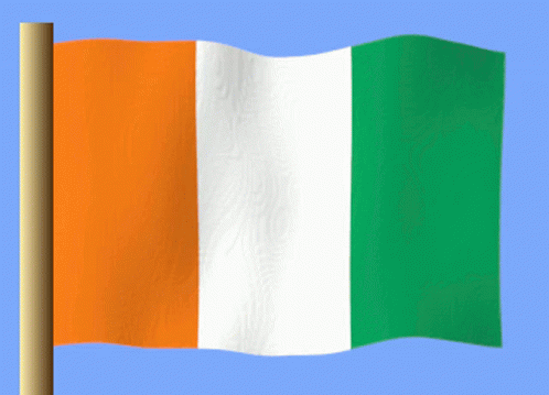 an orange white and green flag is waving in the wind against a blue sky