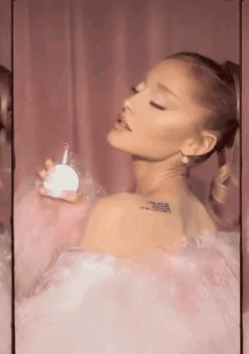 Ariana Grande Holding Perfume Bottle