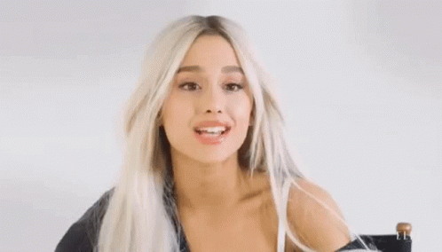 Ariana Grande in Chair with Windblown Hair and Funny Face