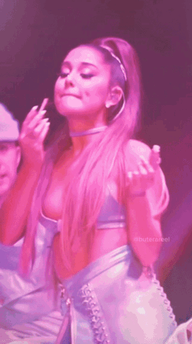 Ariana Grande Is Giving The Middle Finger While Wearing A Pink Top And Skirt GIF