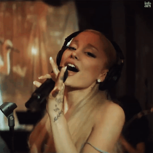 Ariana Grande Is Singing Into A Microphone While Wearing Headphones . GIF