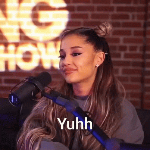 Ariana Grande Is Sitting In Front Of A Microphone With The Word Yuhh On The Bottom GIF