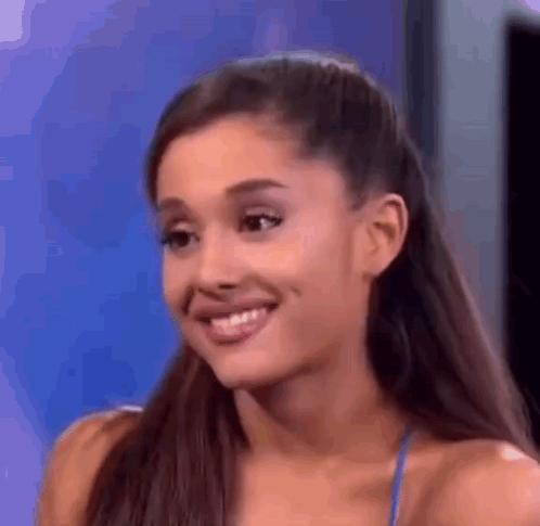 Ariana Grande Is Smiling And Looking At The Camera While Wearing A Blue Top . GIF