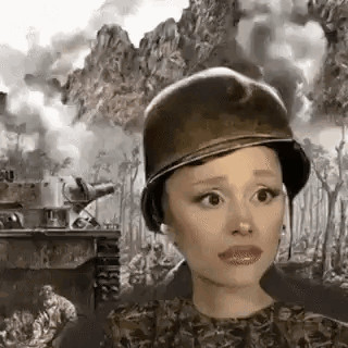 Ariana Grande Is Wearing A Military Helmet In Front Of A Tank . GIF