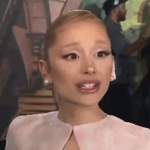 Ariana Grande Is Wearing A White Dress And Earrings And Making A Surprised Face . GIF