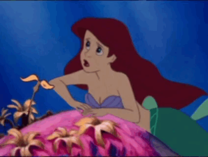 Ariel From The Little Mermaid Is Sitting On A Rock In The Ocean . GIF