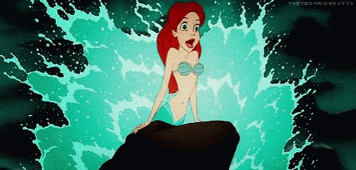 Ariel From The Little Mermaid Sitting On A Rock In The Ocean GIF