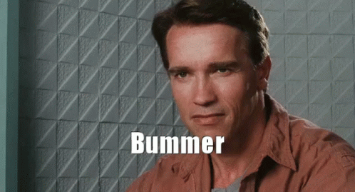 Arnold Schwarzenegger Is Sitting In Front Of A Wall With The Word Bummer Written On It GIF