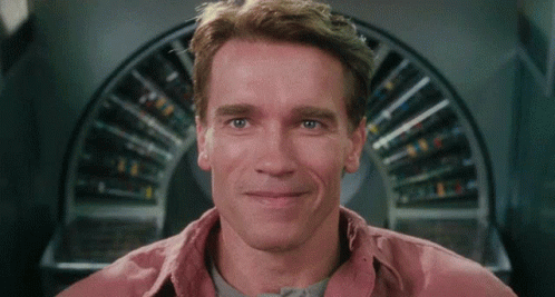 Arnold Schwarzenegger Smiling In Front Of Circular Object GIF