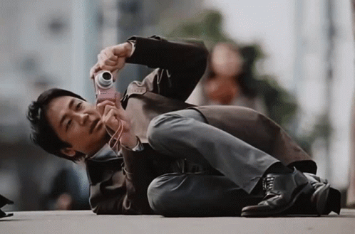 Asian Guy Taking Picture Lying Down GIF