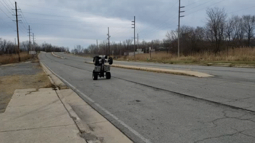 ATV Driving Down Road With Power Lines