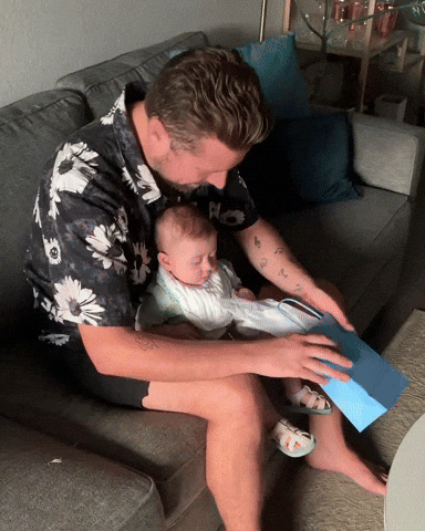 Baby Boy And Daddy Fix Diaper On The Bag GIF