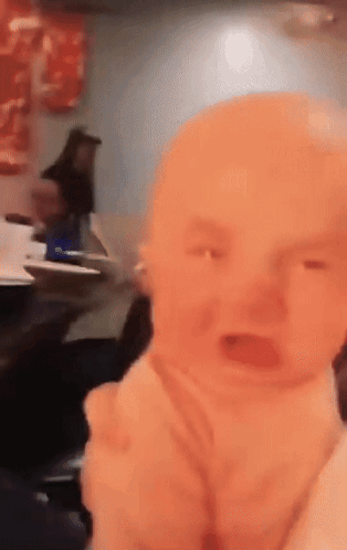 Baby Crying in Restaurant With Woman Behind