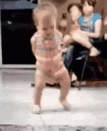 Baby Dancing on Tiled Floor While Woman Holds Another Baby