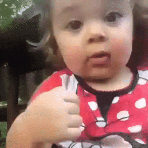 Baby Girl in Minnie Mouse Outfit Thumbs Up