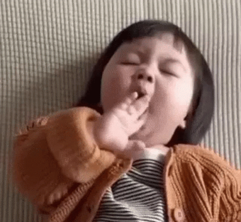 Baby Girl Lying on Bed Eating Fingers