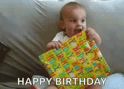 Baby Holding Birthday Present Saying Happy Birthday