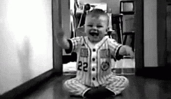 Baby in Baseball Uniform Sitting on Floor Black and White