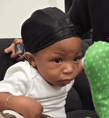 Baby in Black Hat and White Shirt